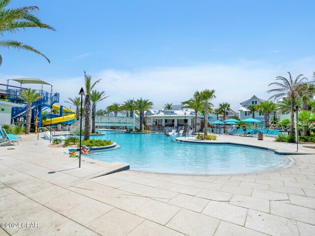 view of pool with a patio and a water slide