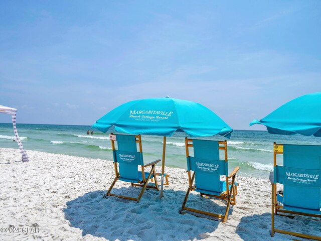 surrounding community featuring a water view and a beach view