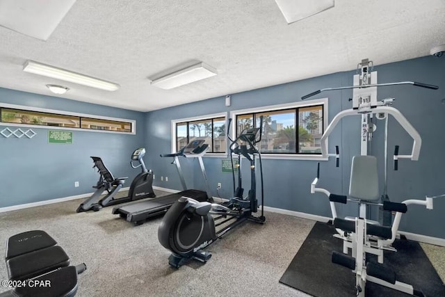 exercise room featuring carpet flooring and a textured ceiling