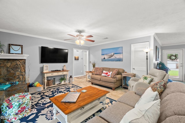 living room featuring ceiling fan, a textured ceiling, and ornamental molding