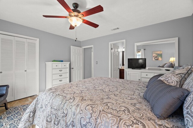 bedroom with a closet, light tile patterned floors, and ceiling fan