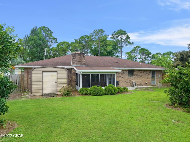 rear view of property with a sunroom, a lawn, and a shed