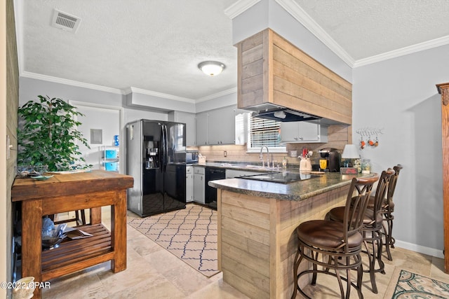 kitchen with a textured ceiling, black appliances, decorative backsplash, kitchen peninsula, and gray cabinetry