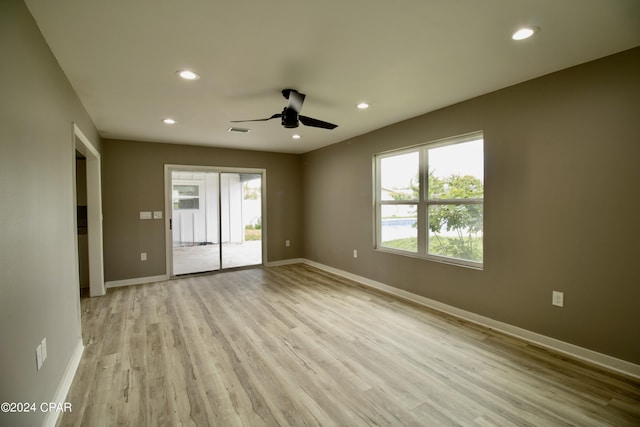 spare room with ceiling fan and light wood-type flooring