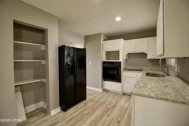 kitchen featuring sink, light hardwood / wood-style flooring, white cabinets, and black appliances