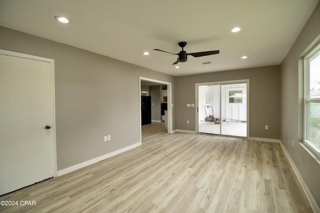 spare room with ceiling fan, a healthy amount of sunlight, and light wood-type flooring