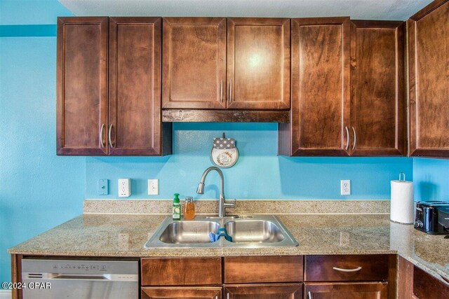 kitchen with sink, dishwasher, and light stone countertops