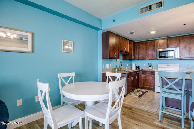 kitchen featuring electric range, sink, and light hardwood / wood-style floors