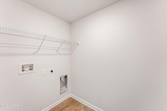 clothes washing area with electric dryer hookup, hookup for a washing machine, and hardwood / wood-style floors