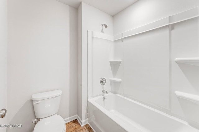 bathroom featuring toilet, wood-type flooring, and shower / tub combination