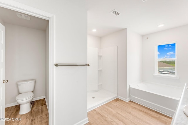 bathroom with hardwood / wood-style floors, independent shower and bath, and toilet