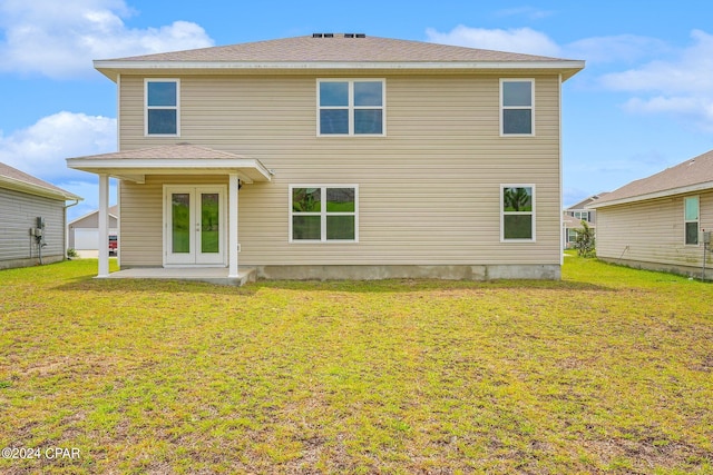 rear view of house featuring a patio area, a lawn, and french doors