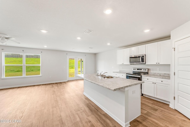 kitchen with light wood-type flooring, white cabinets, ceiling fan, appliances with stainless steel finishes, and sink