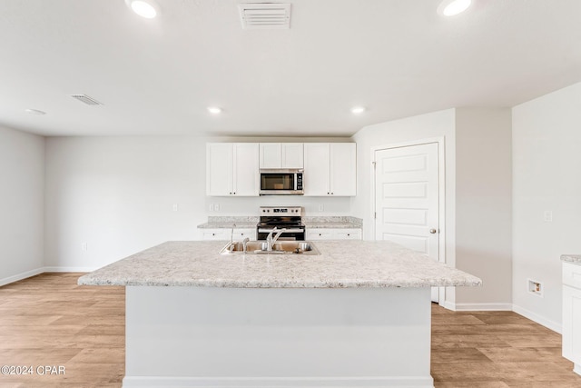 kitchen featuring light hardwood / wood-style flooring, a center island with sink, white cabinets, appliances with stainless steel finishes, and sink