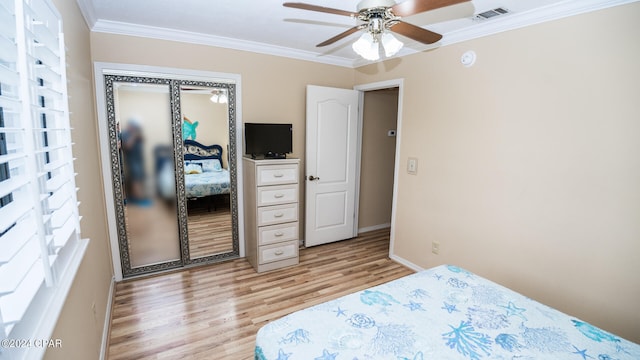 bedroom with ornamental molding, a closet, ceiling fan, and light wood-type flooring