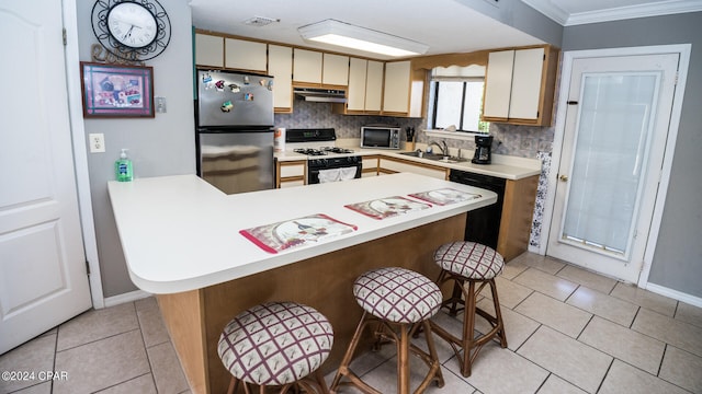 kitchen featuring cream cabinets, stainless steel appliances, decorative backsplash, crown molding, and sink