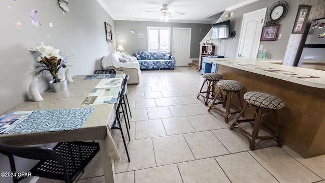 interior space featuring ornamental molding, light tile patterned floors, and ceiling fan