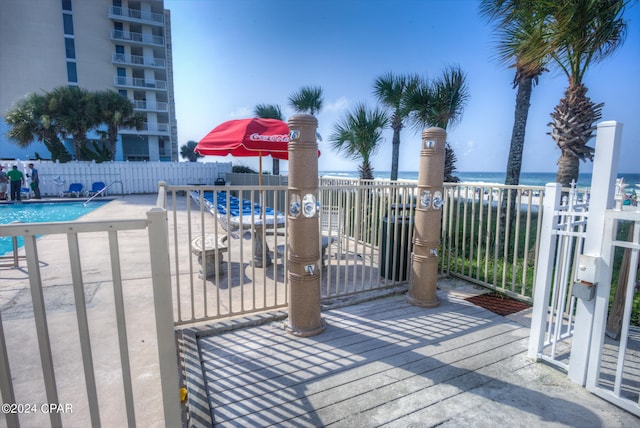 deck with a water view, a patio, and a community pool