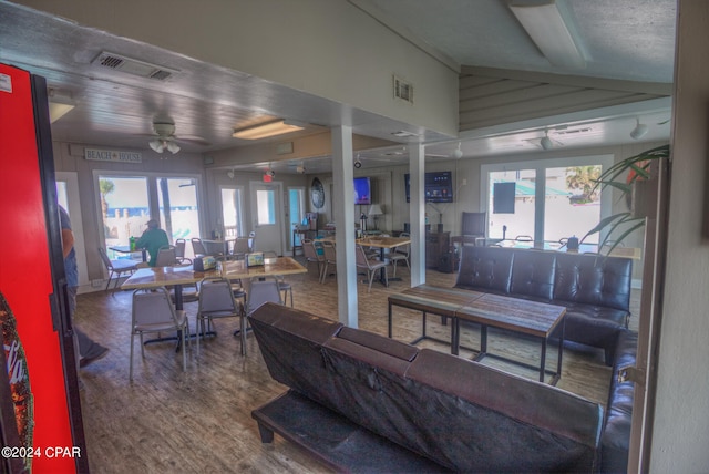 living room with wood-type flooring, ceiling fan, and vaulted ceiling