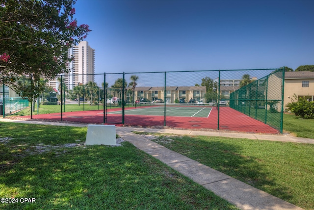 view of tennis court featuring a yard