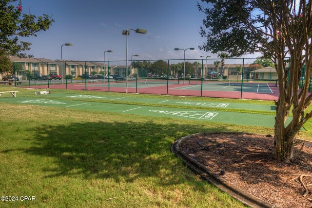 view of sport court with a lawn