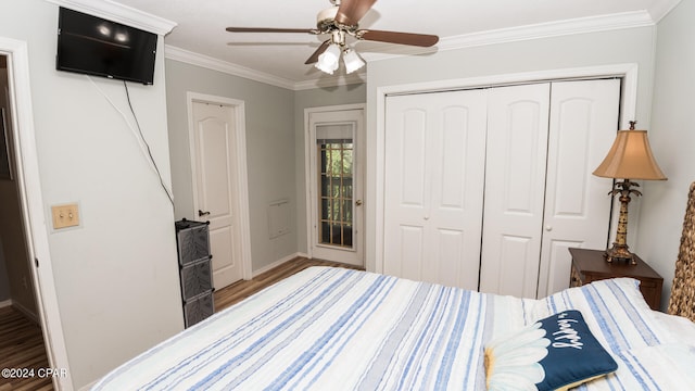 bedroom with crown molding, ceiling fan, wood-type flooring, and a closet