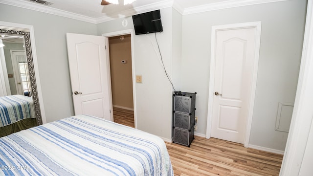 bedroom with ornamental molding, light wood-type flooring, and ceiling fan