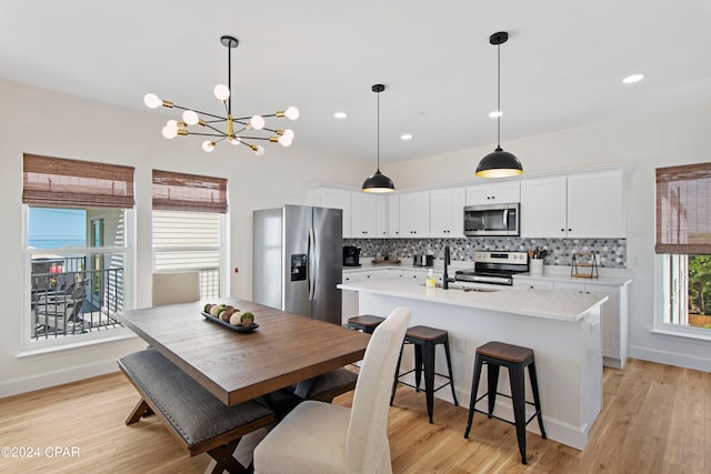 dining area featuring a chandelier, light wood-type flooring, and sink