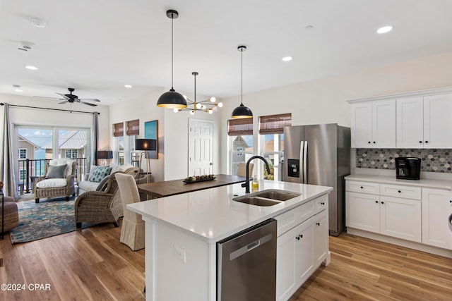 kitchen featuring tasteful backsplash, an island with sink, stainless steel appliances, light hardwood / wood-style floors, and sink