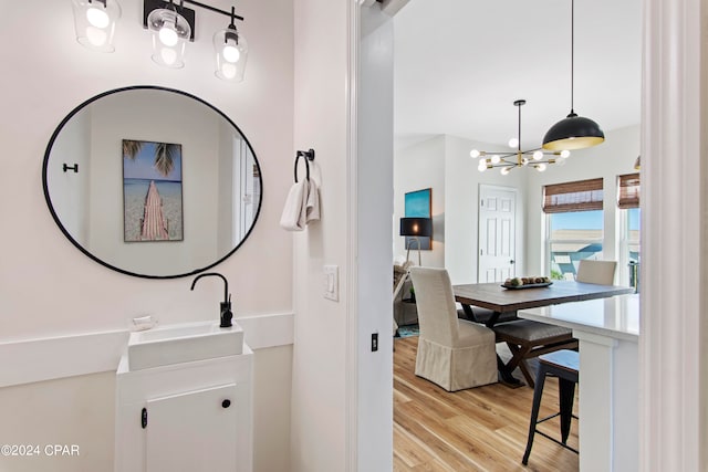 bathroom featuring a notable chandelier, sink, and hardwood / wood-style flooring