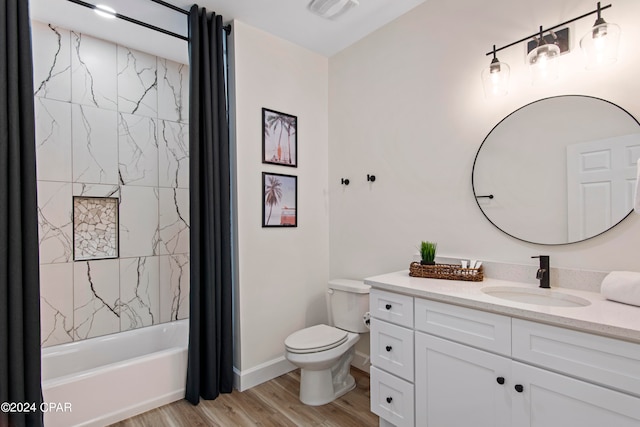 full bathroom featuring hardwood / wood-style flooring, tiled shower / bath combo, toilet, and vanity