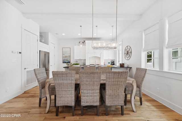 dining space with an inviting chandelier and light hardwood / wood-style flooring