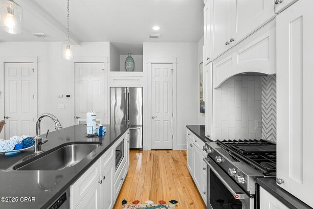 kitchen featuring stainless steel range, premium range hood, white cabinetry, and backsplash