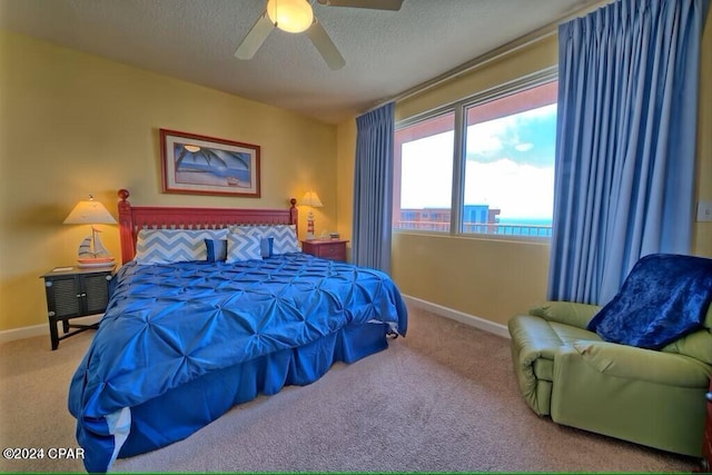 carpeted bedroom featuring a textured ceiling and ceiling fan