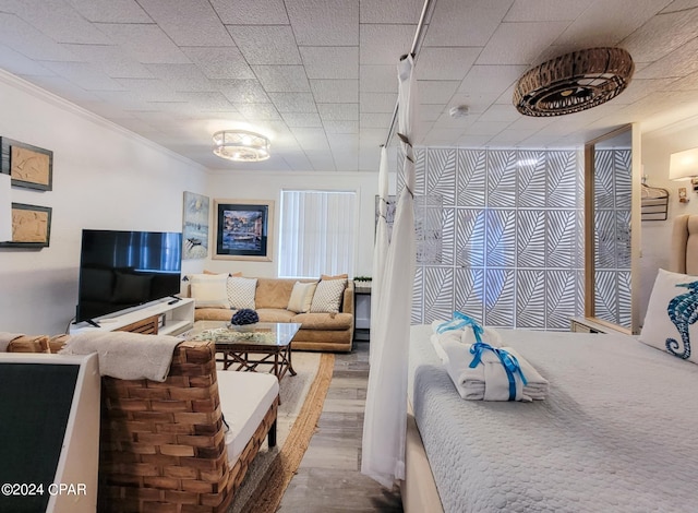 bedroom featuring crown molding and wood-type flooring