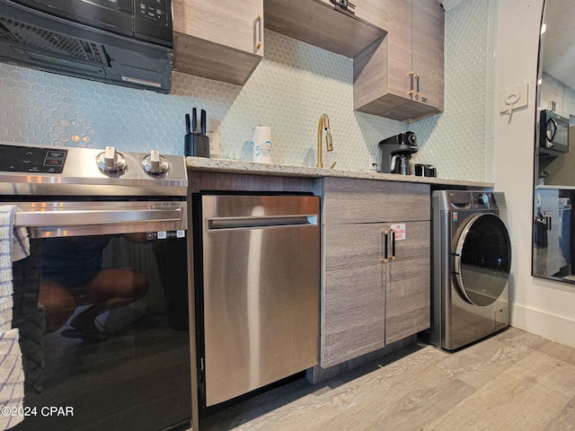 laundry area with washer / dryer and light wood-type flooring