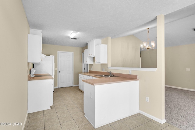 kitchen with white fridge, a notable chandelier, light carpet, decorative light fixtures, and sink