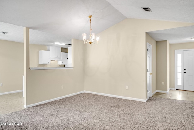 unfurnished dining area with a chandelier, a textured ceiling, lofted ceiling, and light colored carpet