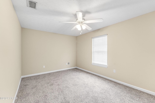 carpeted empty room featuring a textured ceiling and ceiling fan