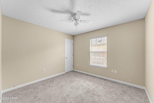 carpeted spare room featuring a textured ceiling and ceiling fan