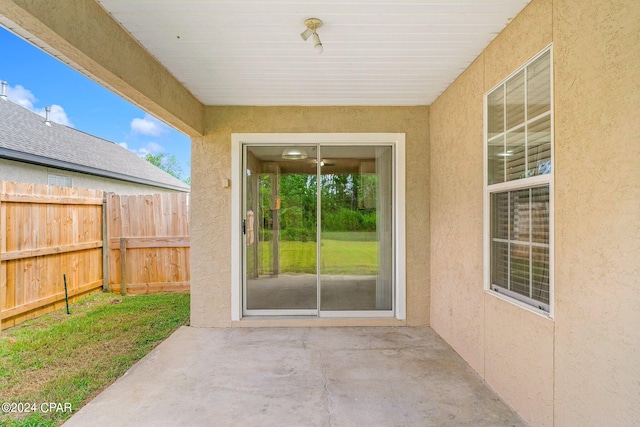 view of exterior entry with a patio area