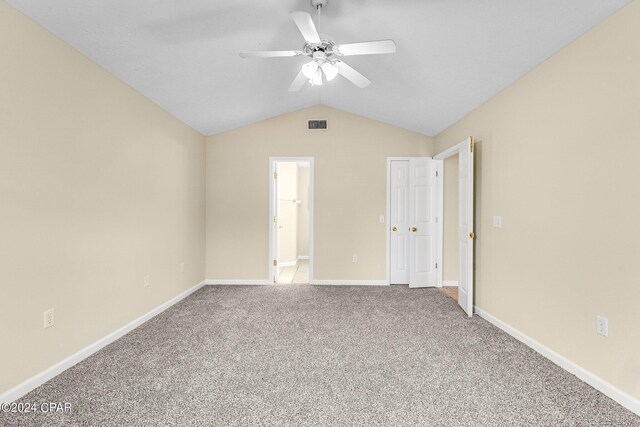 interior space with carpet flooring, ceiling fan, and vaulted ceiling