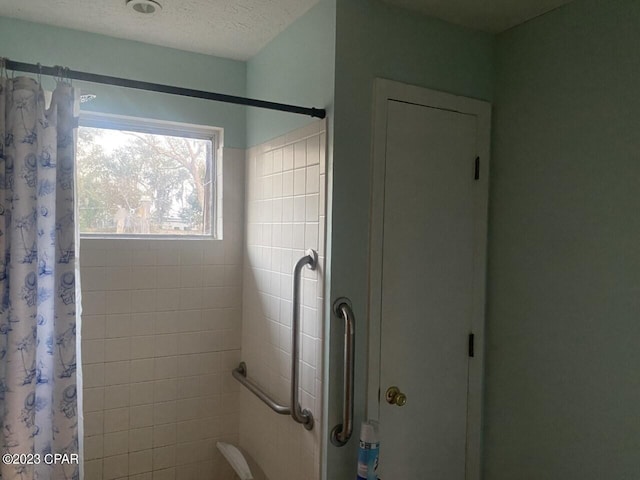 bathroom featuring a textured ceiling and a shower with shower curtain