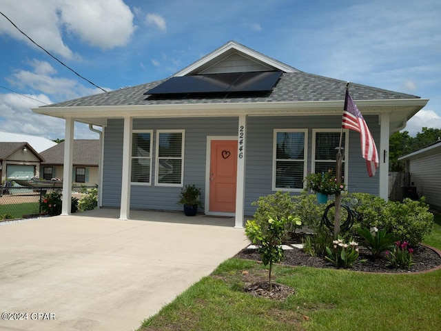 bungalow-style home with solar panels and covered porch