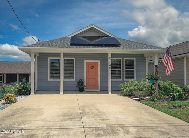 bungalow featuring solar panels and a porch