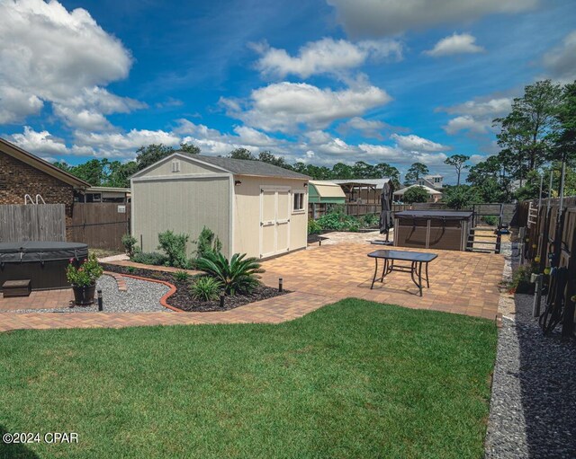 view of yard with a patio, a hot tub, and a storage shed