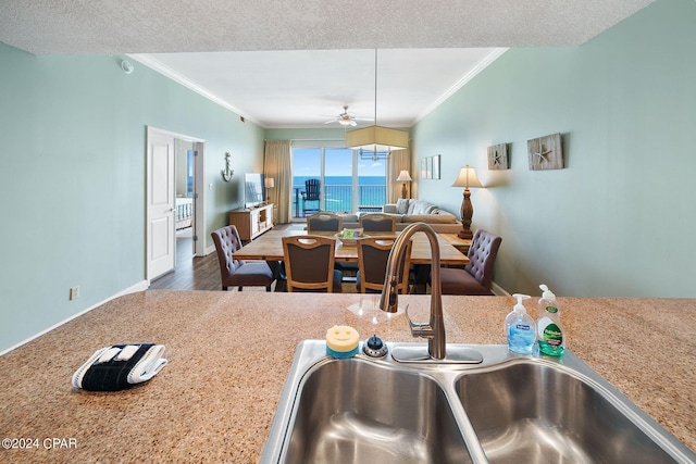 kitchen featuring a textured ceiling, ceiling fan, hardwood / wood-style floors, and sink