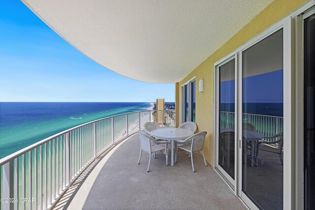 balcony with a water view and a beach view