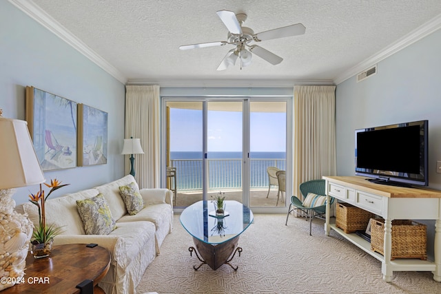 living room with ceiling fan, visible vents, carpet flooring, and ornamental molding