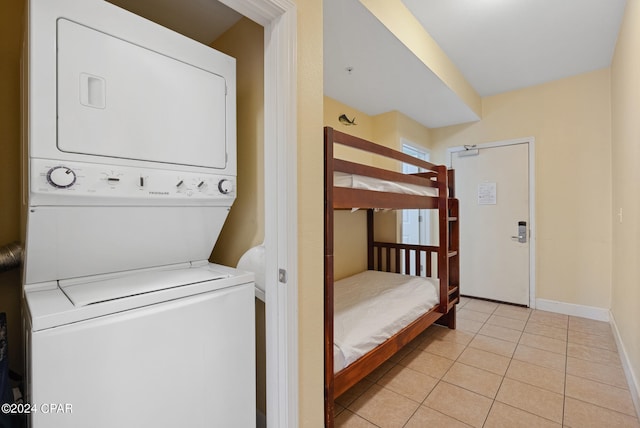 washroom with light tile patterned flooring and stacked washer / dryer